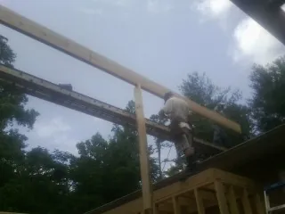 Carpenter setting a ridge beam over a new addition frame — Ice Dam Removal by Roofing Brothers in Wanamingo