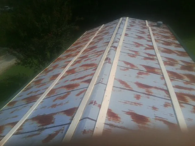 Rusted metal roof panels with new wood purlins before replacement — Storm Damage Roof Repair in Wanamingo by Roofing Brothers